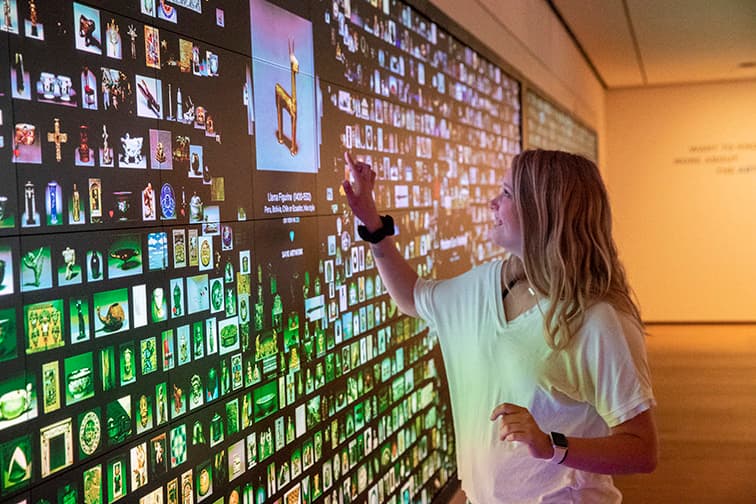 A visitor interacting with the colorful ArtLens Wall